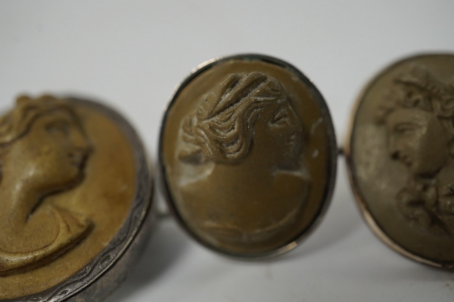 Three assorted carved cameo lava brooches, largest 32mm, together with a pair of similar earrings and a 930s and cameo lava ring. Condition - poor to fair